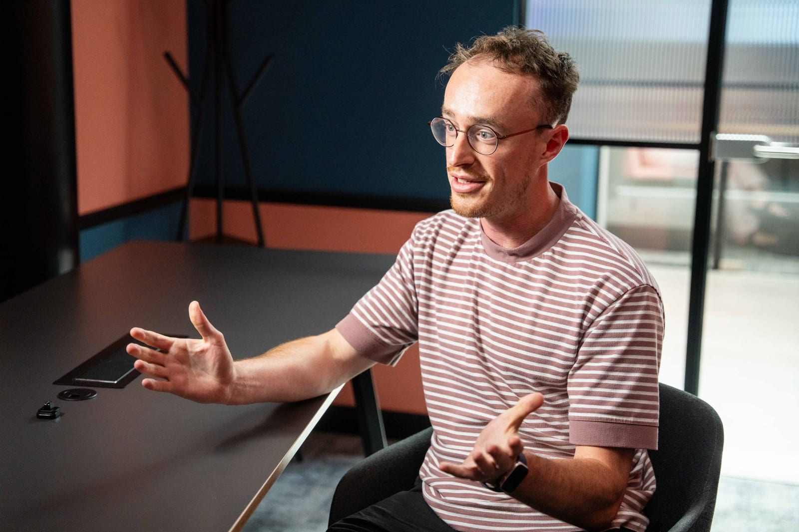 Dafydd Jones of Ninth Seat mid-sentence at a meeting table, hands open