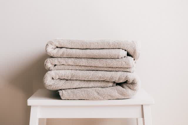 Folded towels stacked on a white stool